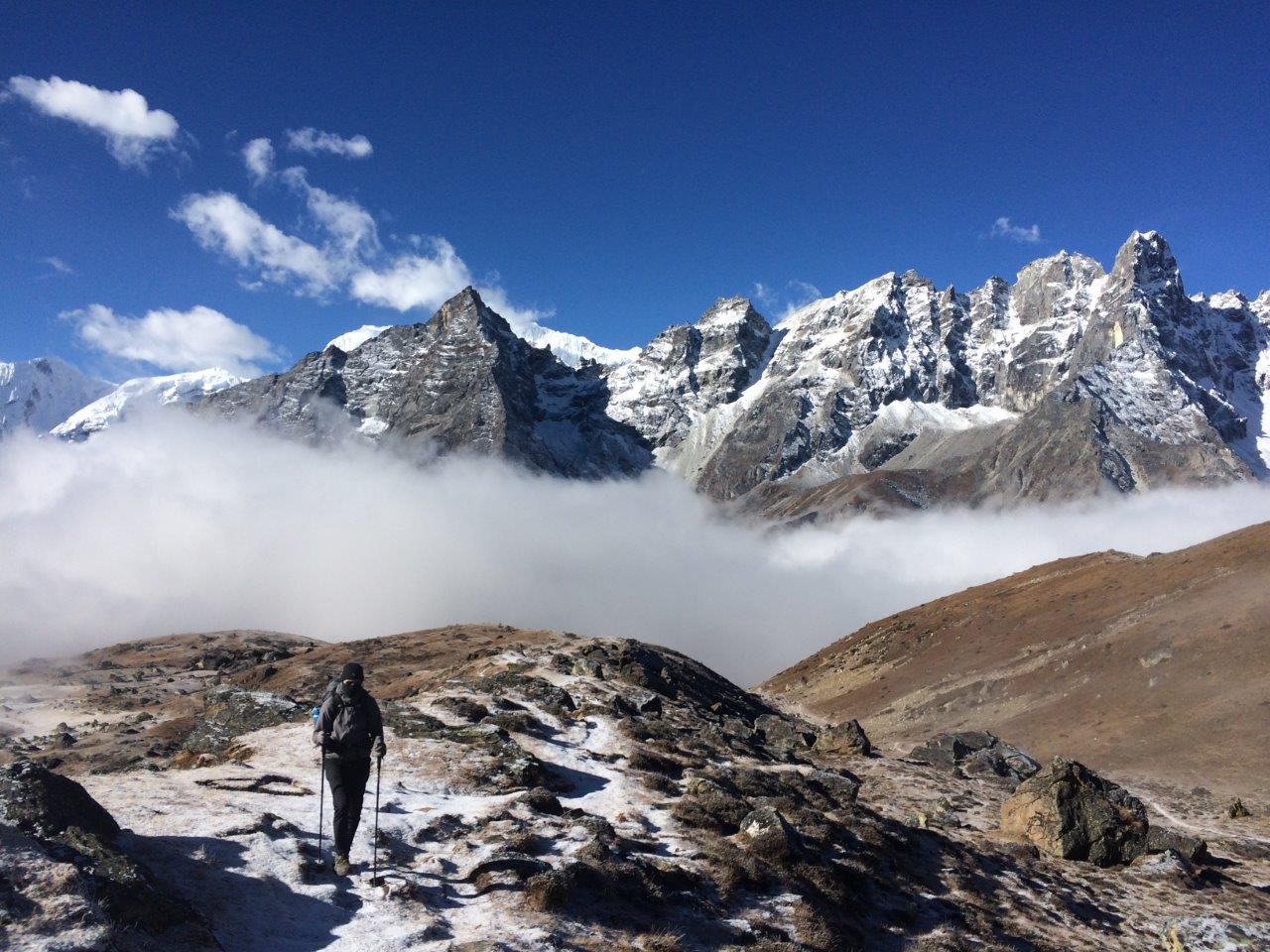 Man hiking in front of snow covered mountains inspiring hiking captions