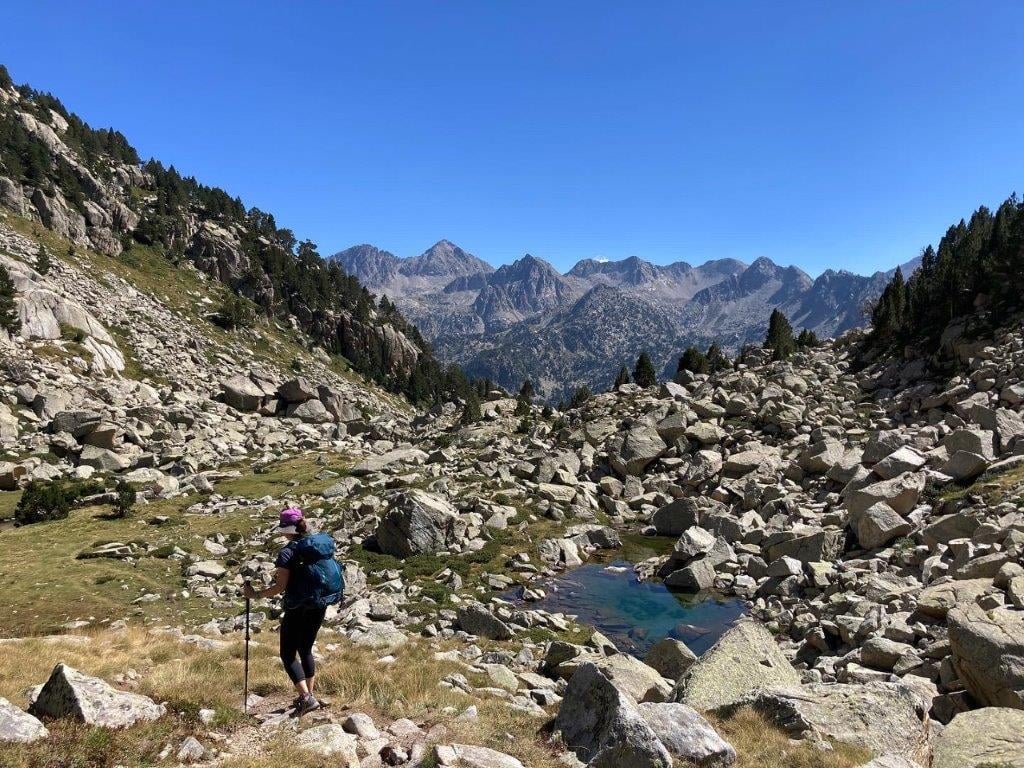 Woman hiking through a rocky mountain valley on the Carros de Foc