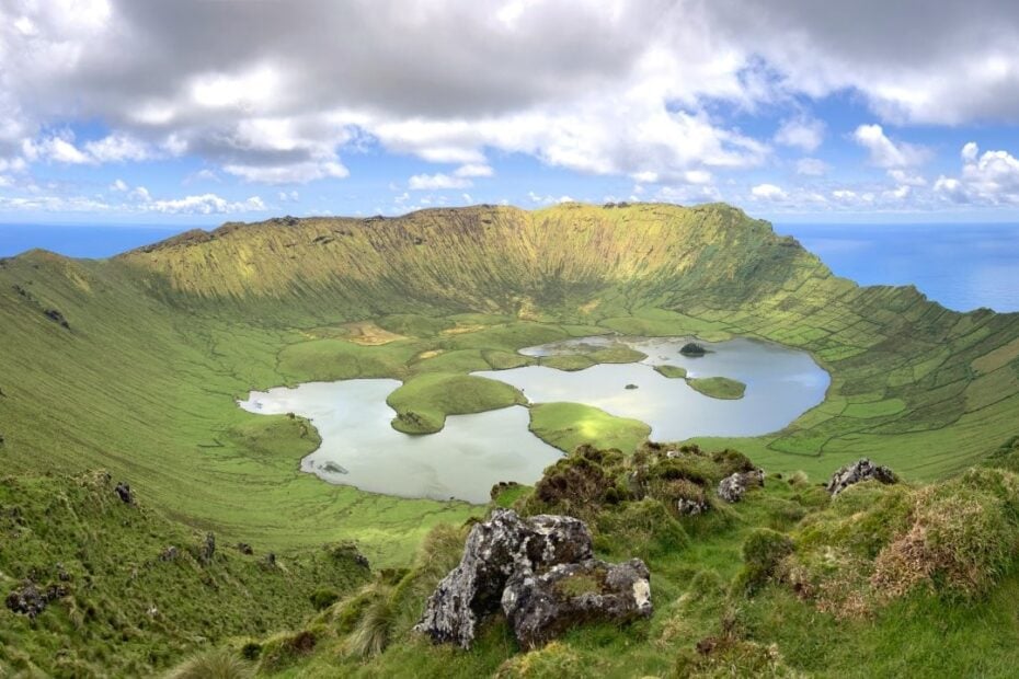 Lush green caldera on Corvo Azores with lakes at the bottom and the ocean in the background