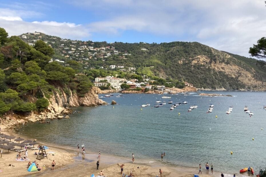 Beach in a small bay hemmed in by green hills in Begur Spain