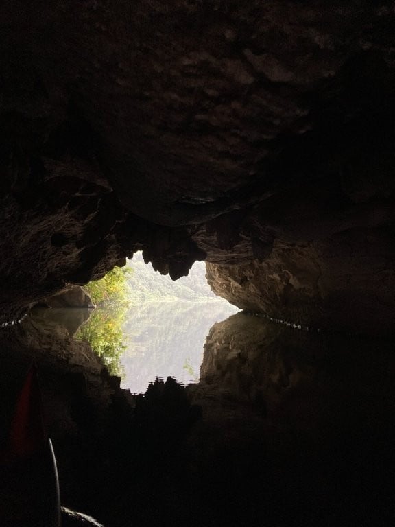 Small cave opening reflected off the calm water