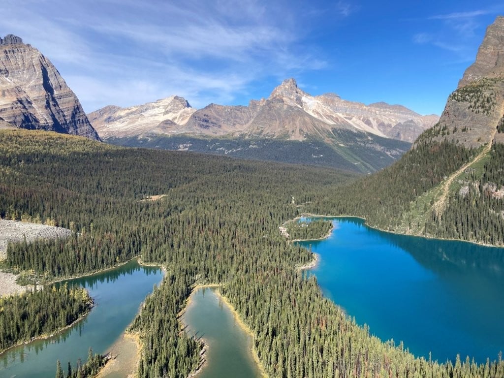 Three different coloured lakes surrounded by forest and mountains