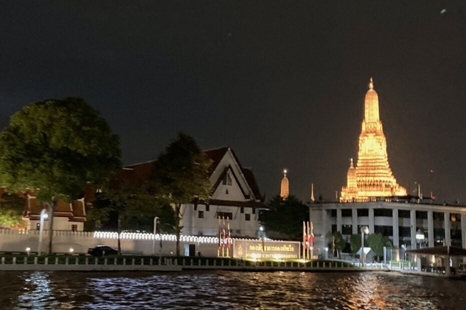 Thai temple lit up at night on the river