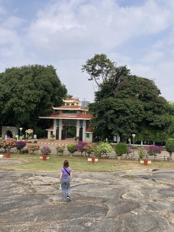 Woman walking down rocky slope toward a temple arch