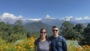 Couple in front of flowers with mountains in the background
