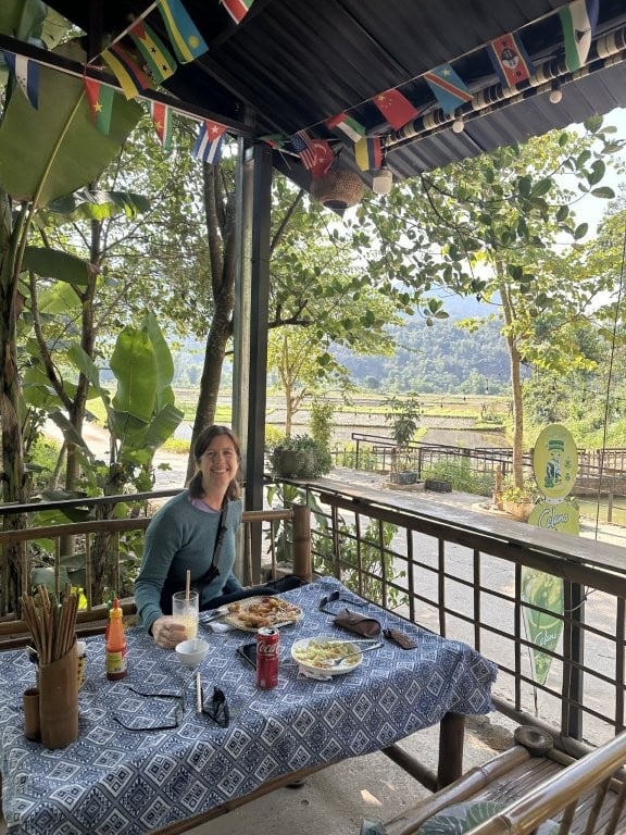 Woman eating lunch with a view of rice fields
