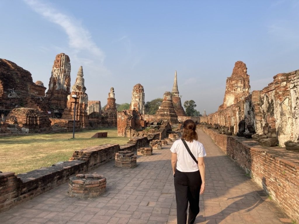 Woman walking through ancient Thai ruins