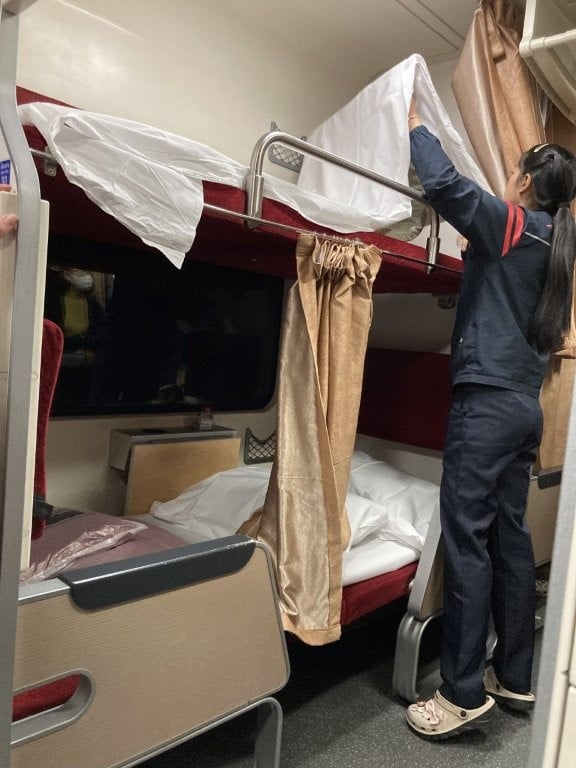 Woman making up beds on a Thai sleeper train