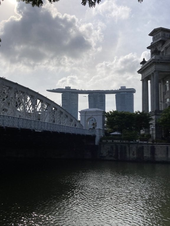 White bridge and three--building hotel in background