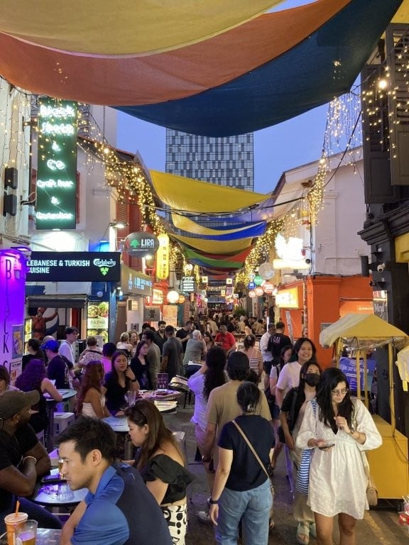 Crowded narrow street with bars