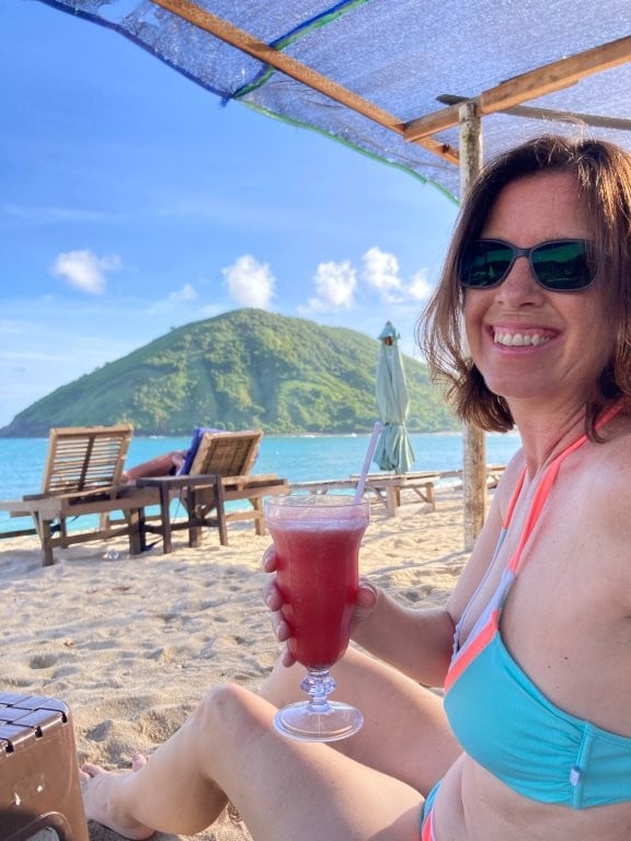 Woman having a watermelon smoothie on the beach