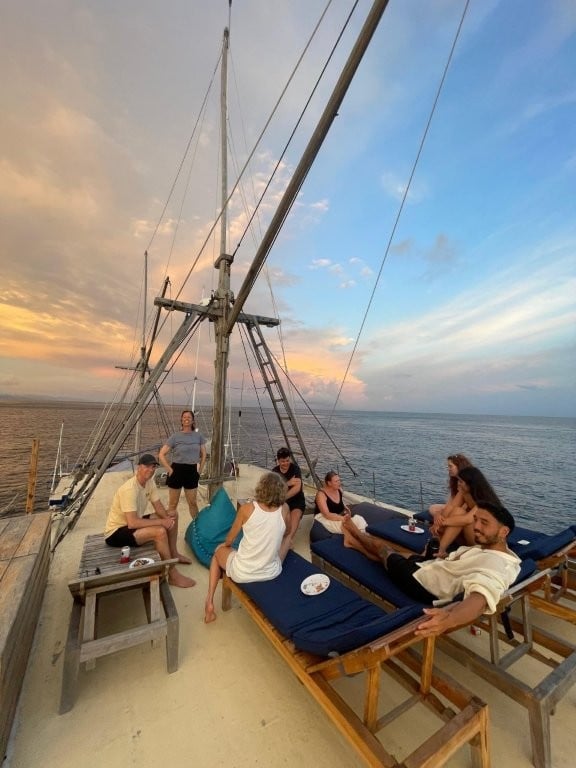 Group of divers on the top deck at sunset