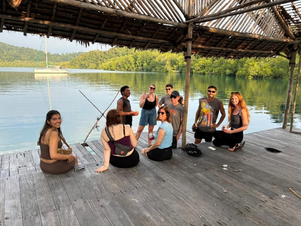 Group relaxing on the deck of an abandoned resort in Raja Ampat