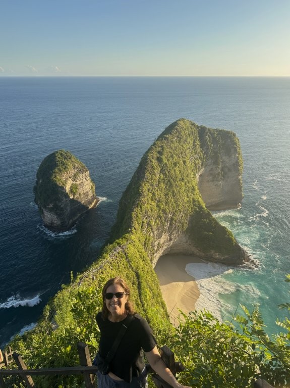 Woman on stairs overlooking beach cliffs