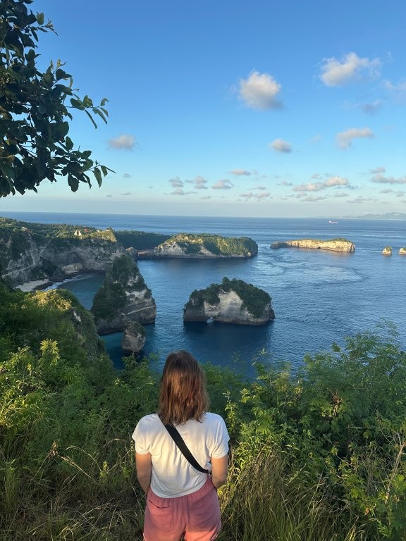 Woman looking out at rocky islets in Nusa Penida