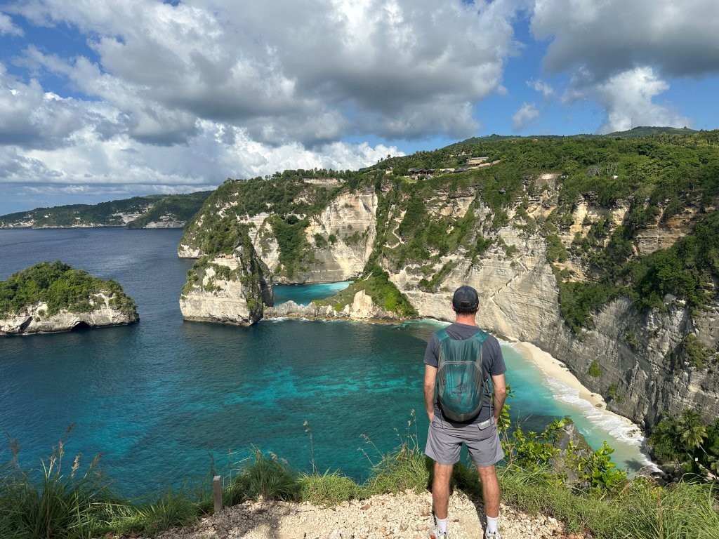 Man looking down on Diamond Beach from a high cliff