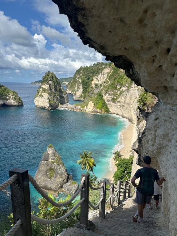 Man on stairs heading down to a rocky scenic beach
