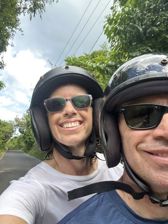 Couple selfie wearing helmets riding a moped on Nusa Penida