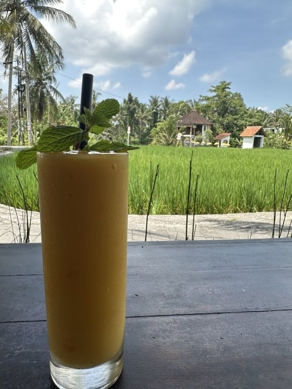Mango smoothie and green rice fields
