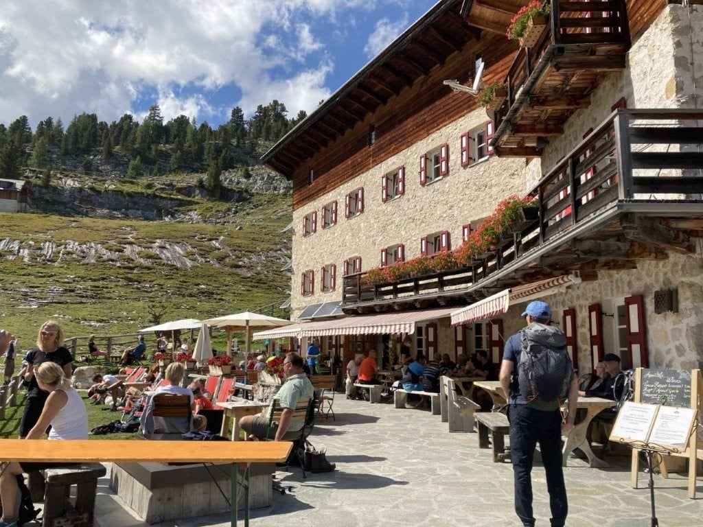 Hiker approaching a busy Italian rifugio