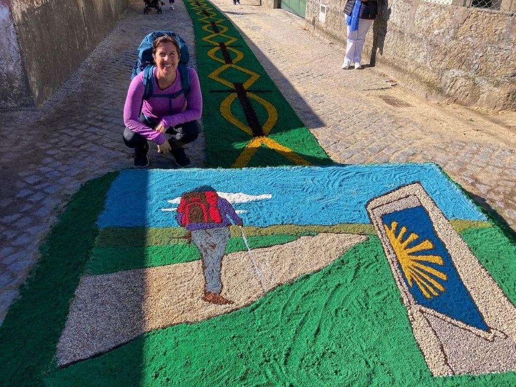 Woman crouched next to a decorative Easter carpet