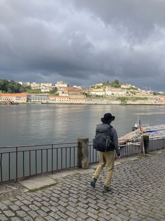 Hiker leaving Porto along the river