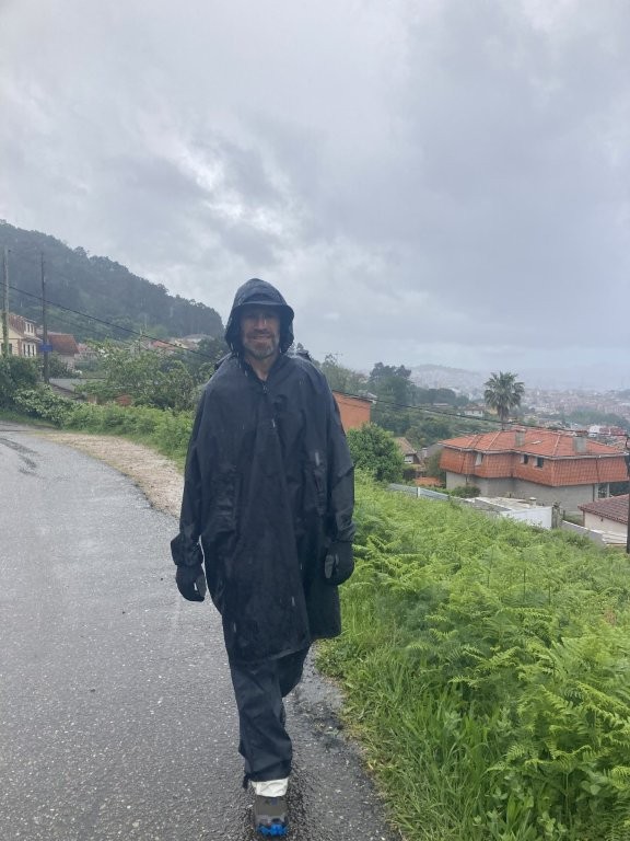 Man in poncho hiking in the rain
