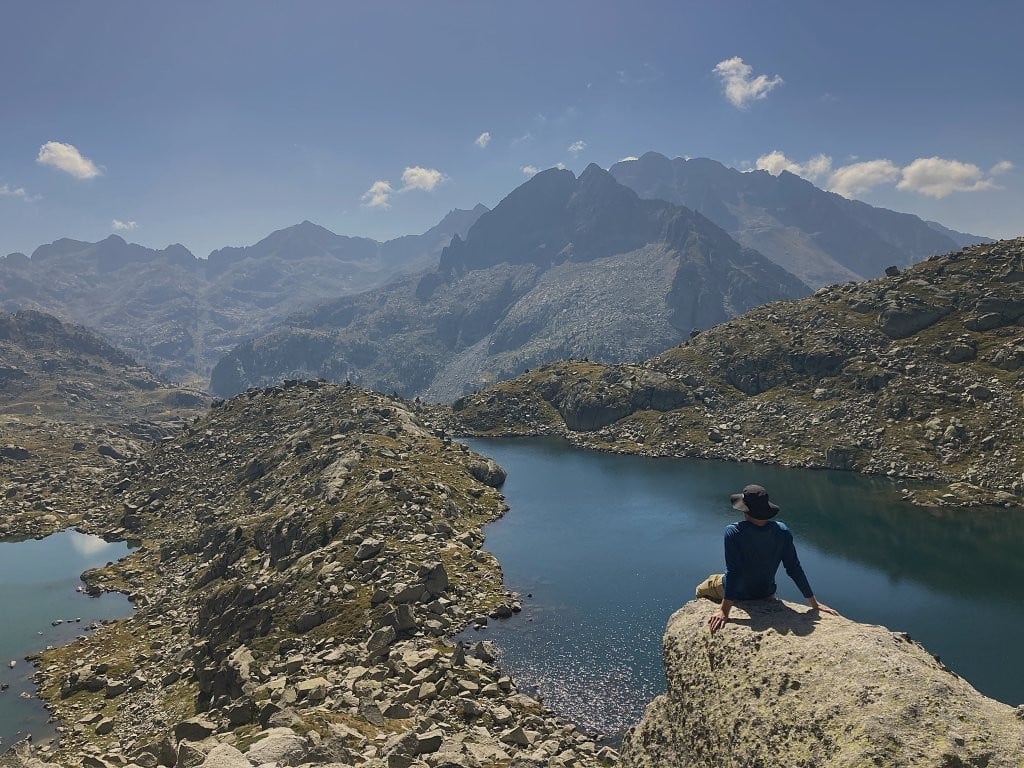 Man on rock overlooking mountain lakes