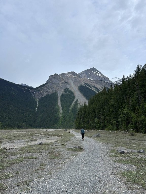 Hiker crossing flat plain toward mountain
