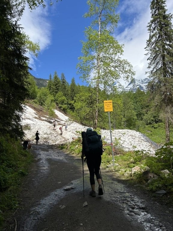 Hiker approaching snowy avalanche area