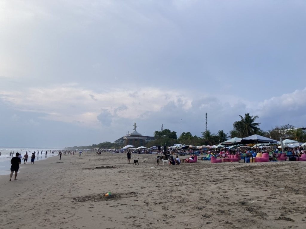 Wide brown beach with lots of bars and umbrellas