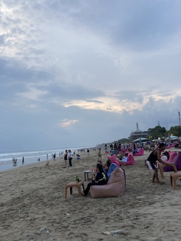 People sitting in beanbag chairs on the beach in Bali