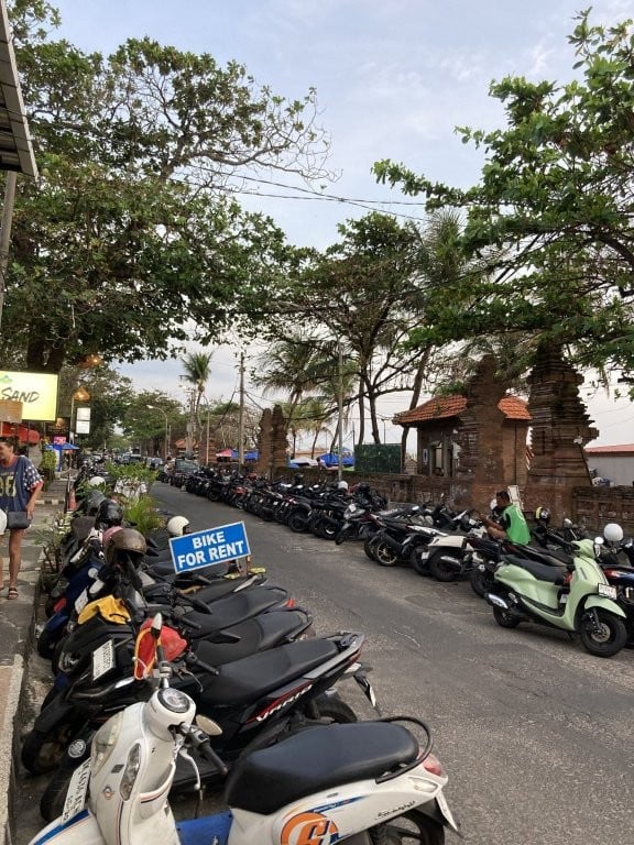 Rows of scooters for rent next to Legian Beach Bali