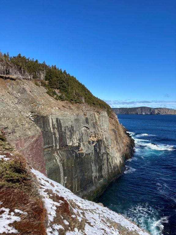 Snowy grass along the rocky coastline