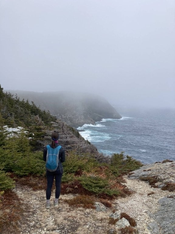 Hiker looking out at foggy coastline