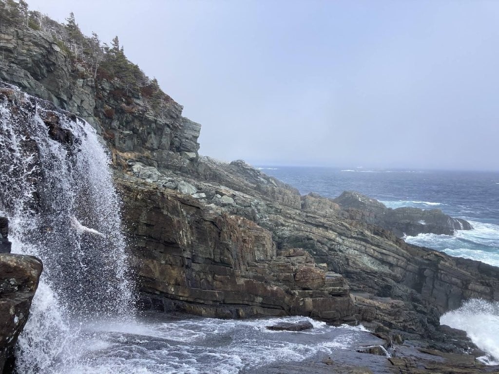 Waterfall dropping into rocks on the coast