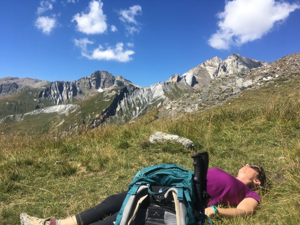 Hiker resting in a grassy meadow on the Tour du Mont Blanc