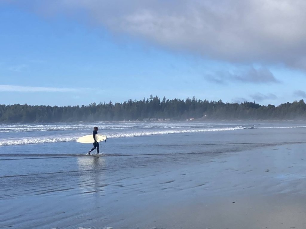 Surfer carrying his board out of the ocean