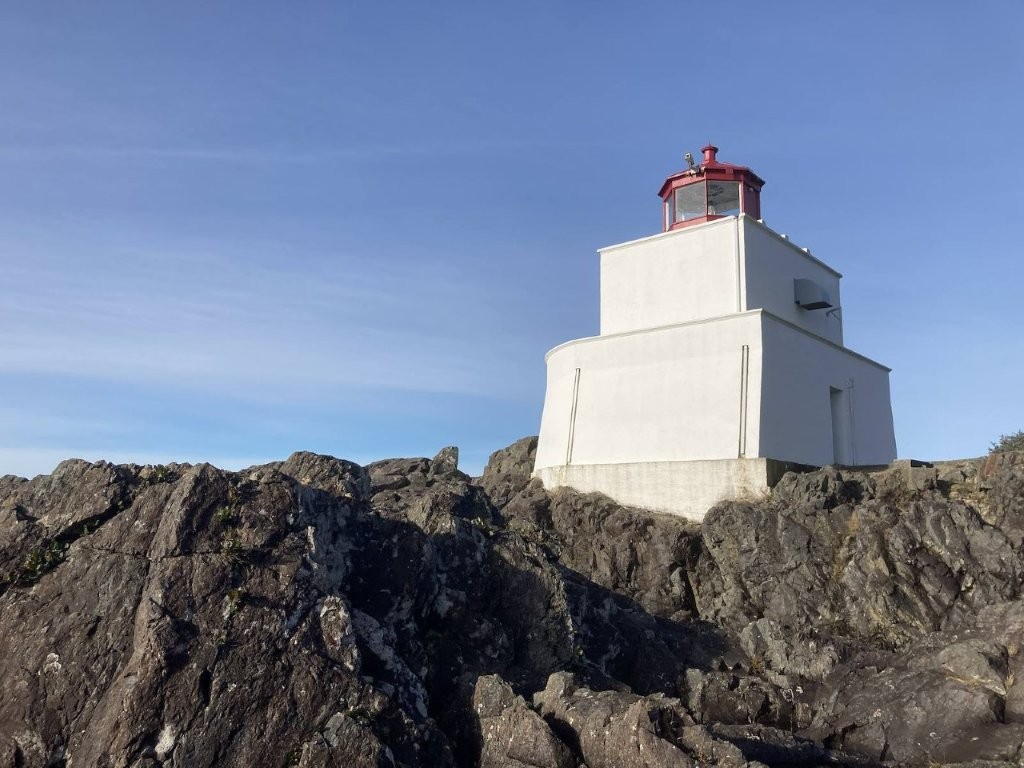 Square white lighthouse on a rocky hill