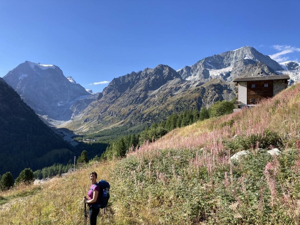 Woman hiking through wildflowers on the Walker's Haute Route in Switzerland