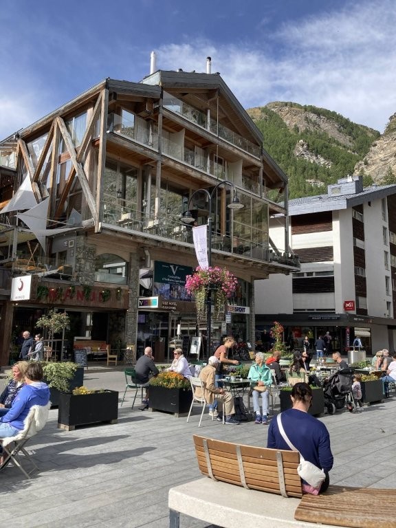 Man on a bench in a square in Zermatt