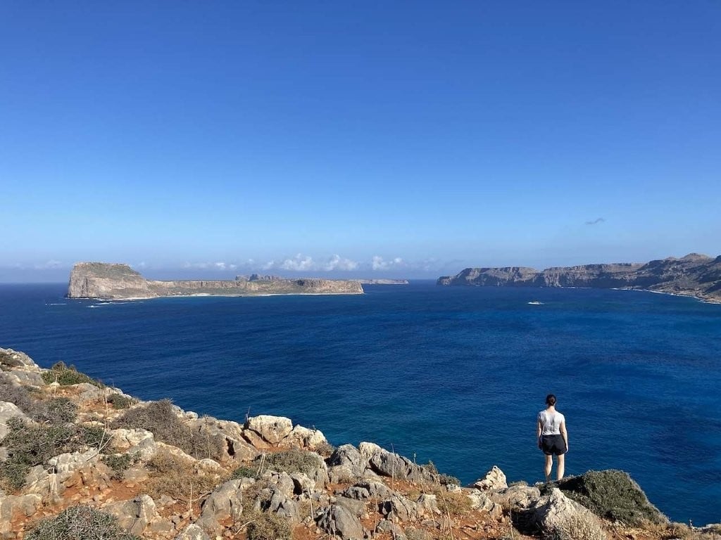Woman hiking on hill overlooking ocean and islands