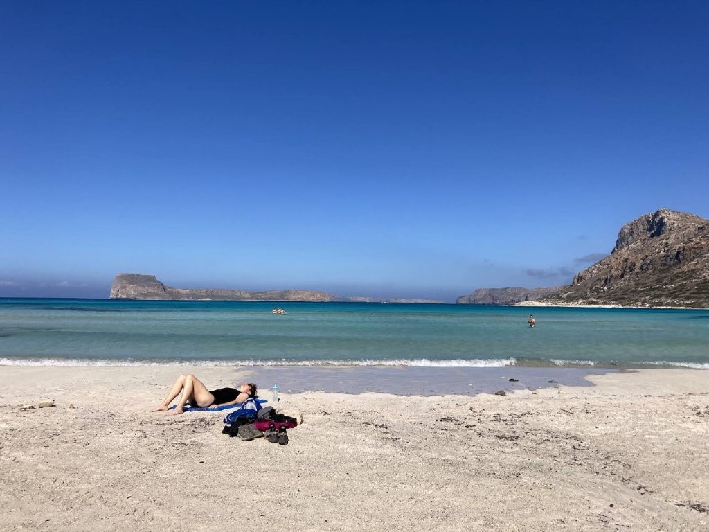 Woman sunbathing with ocean and islands in background