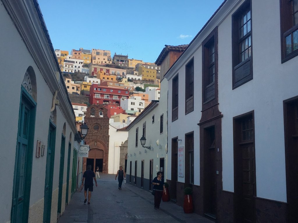 Narrow walking street backed by colourful hillside town