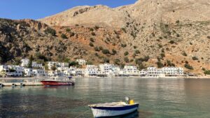 Fishing boat and white village of Loutro in Greece
