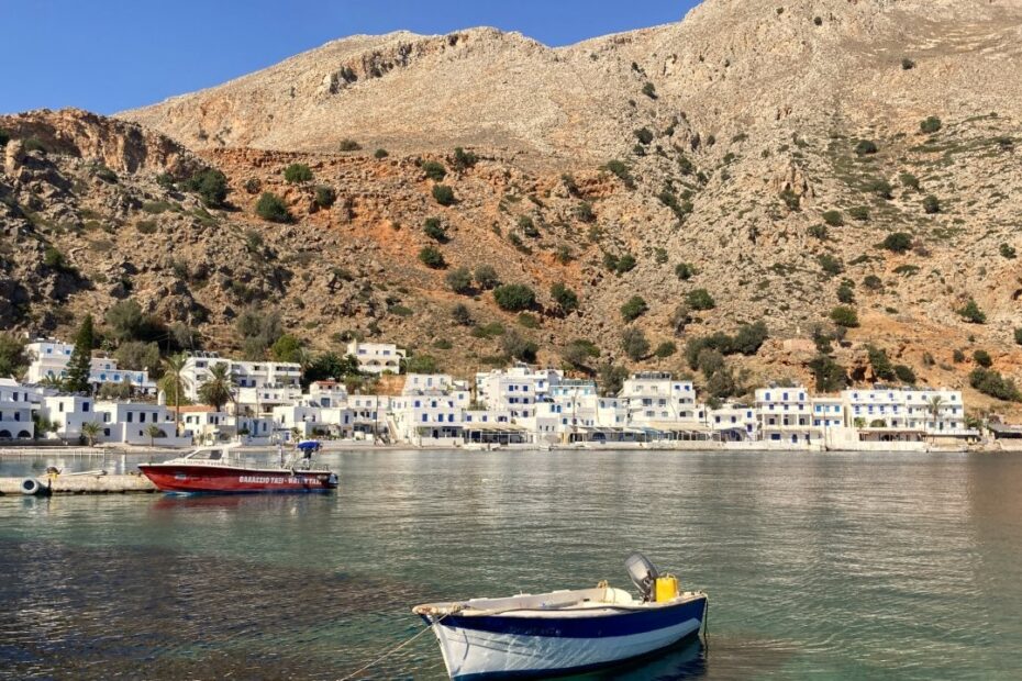 Fishing boat and white village of Loutro in Greece