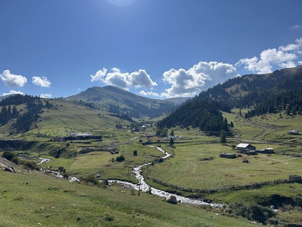 Creek running through green hills and pastures in Jyrgalan
