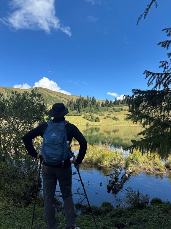 Hiker looking out over calm lake