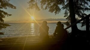 Two women on the beach at sunset over the lake