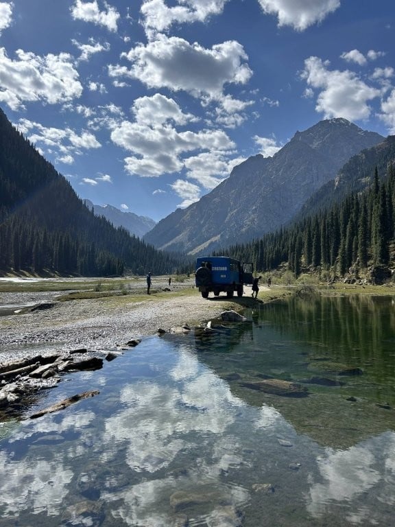 Large jeep next to alpine lake